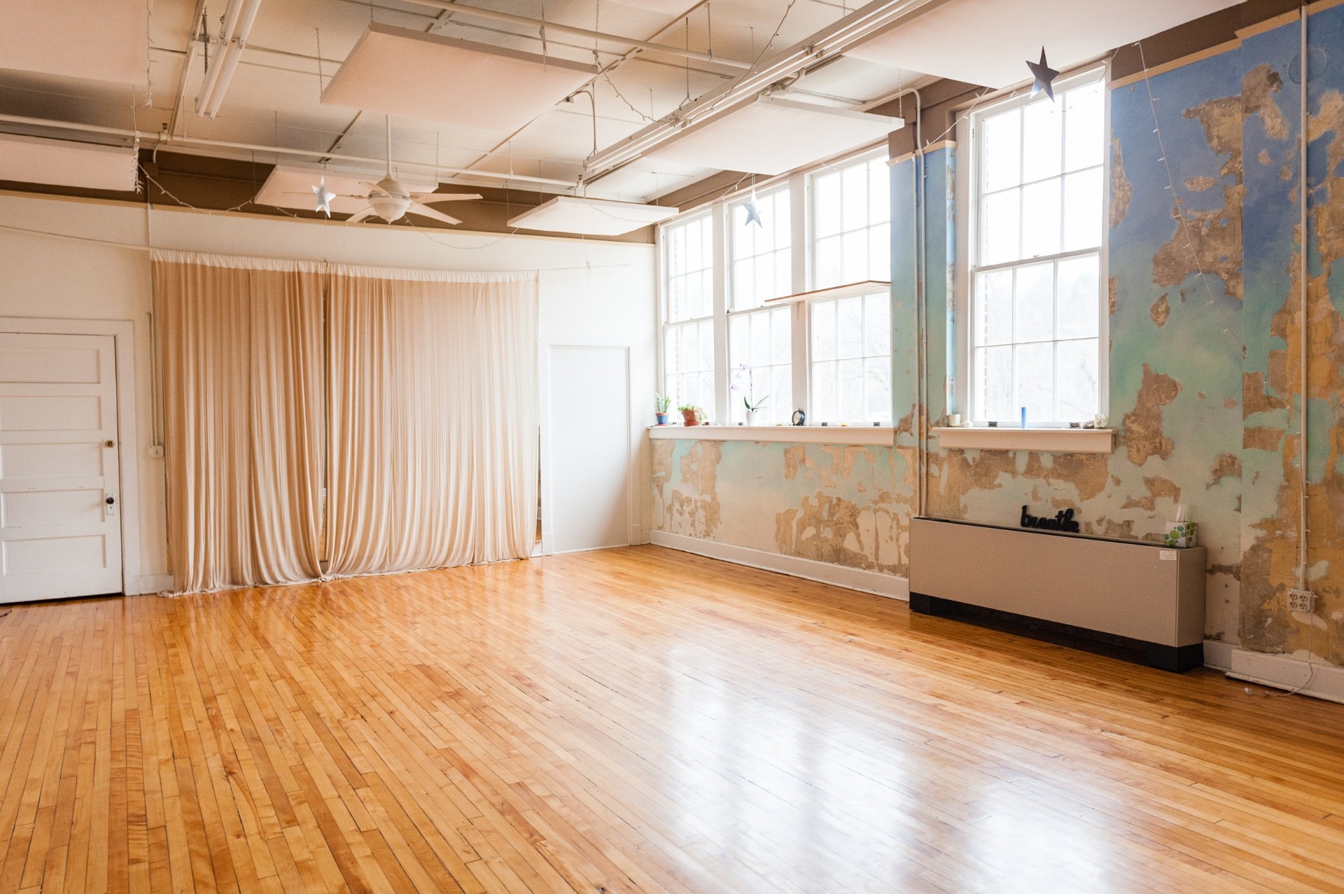 Magictown studio interior with wood floors and tall antique windows